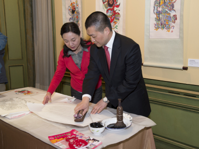 The Chinese Deputy Chief of Mission, Minister Lu Kang, and artist, Yang Huiping, demonstrate the process woodblock print making at this year’s Chinese Lunar New Year celebration. Photograph by Kaveh Sardari.