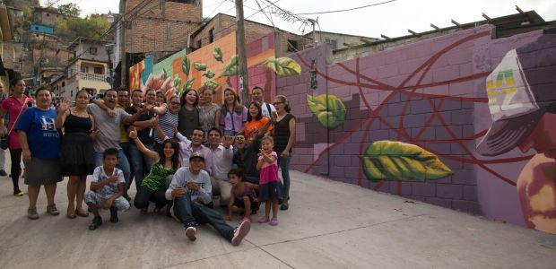 Artist Michelle Angela Ortiz, her assistants, and community volunteers from la Colonia 21 de Febrero in front of their mural.