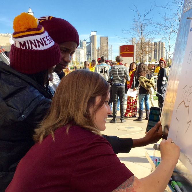 Murrow participants from Africa work with a University of Minnesota student to make banners for the Gophers game that afternoon. Photo by Cynthia Norcross Willson