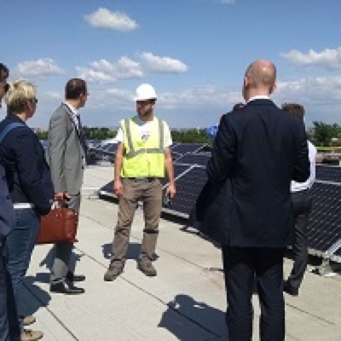 An IVLP Energy Security group from Europe surveys solar panels installed by students atop a school in Anacostia, District of Columbia