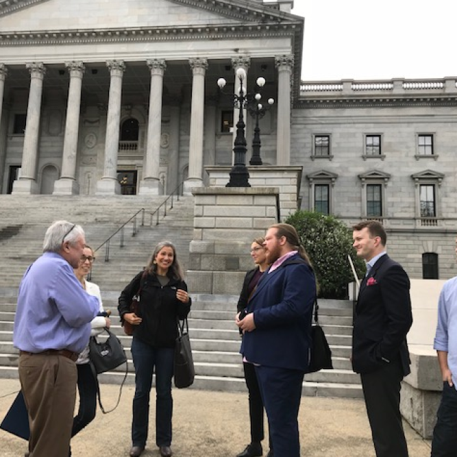 Swedish journalists and members of the Palmetto Council for International Visitors, Jim Byrum and Lisa Ewart, stand outside of the State House in Columbia, South Carolina while on a tour of the city.