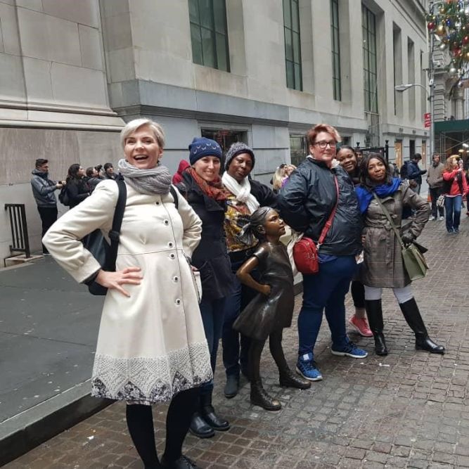 Participants from the "Women in Entrepreneurship" project in December 2018 meet the Fearless Girl outside the New York Stock Exchange.