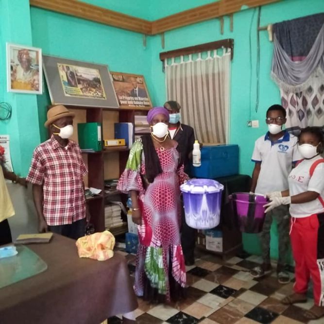 Abigael (right with bookbag) with ADJE members leading a handwashing workshops with community members. Photo credits to AJDE.