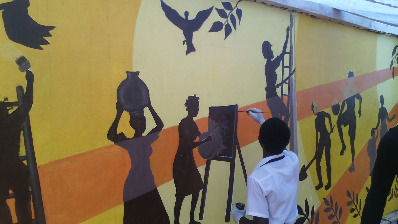 One of the local artists puts finishing touches on the Bukavu mural.