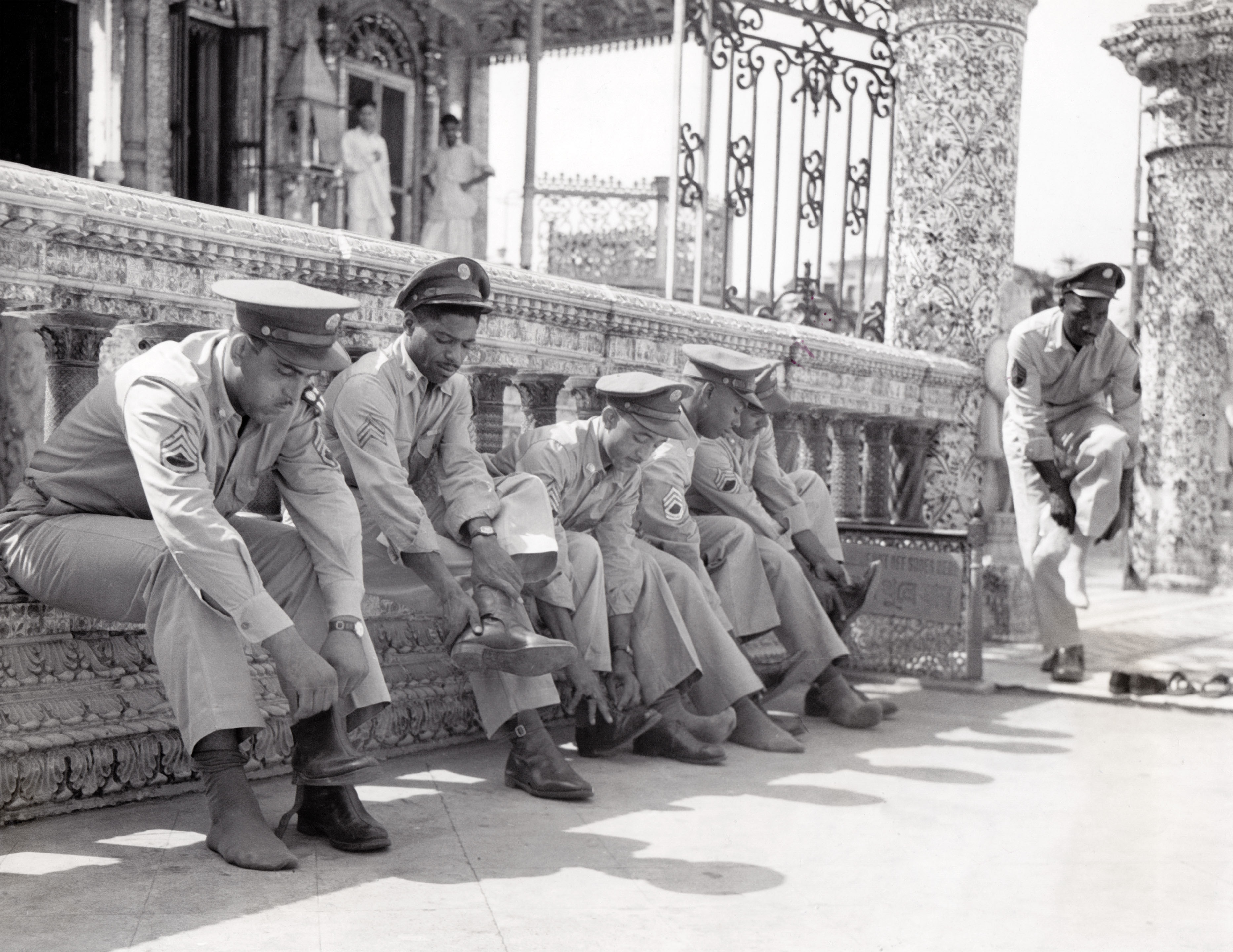 U.S. soldiers respectfully remove shoes before entering the Calcutta Jain Temple, 1943 Calcutta, West Bengal 