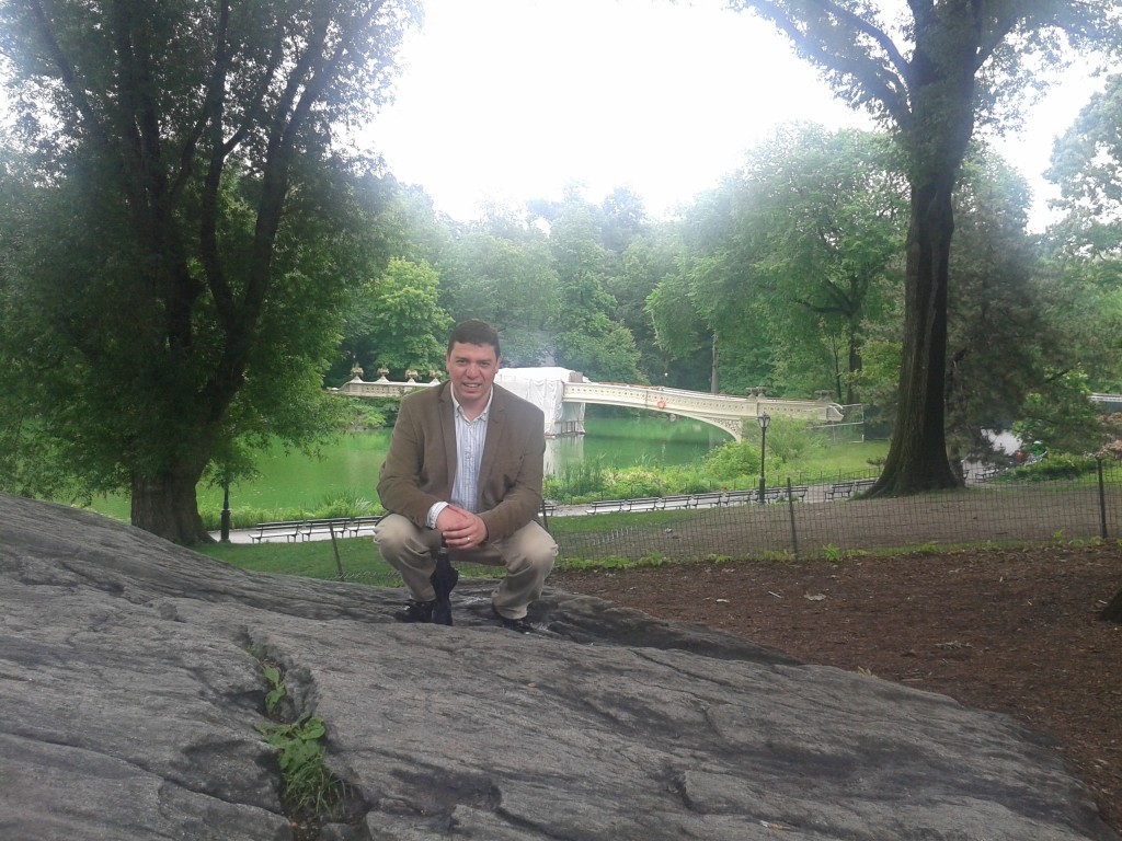 Pedro Prado kneeling in Central Park